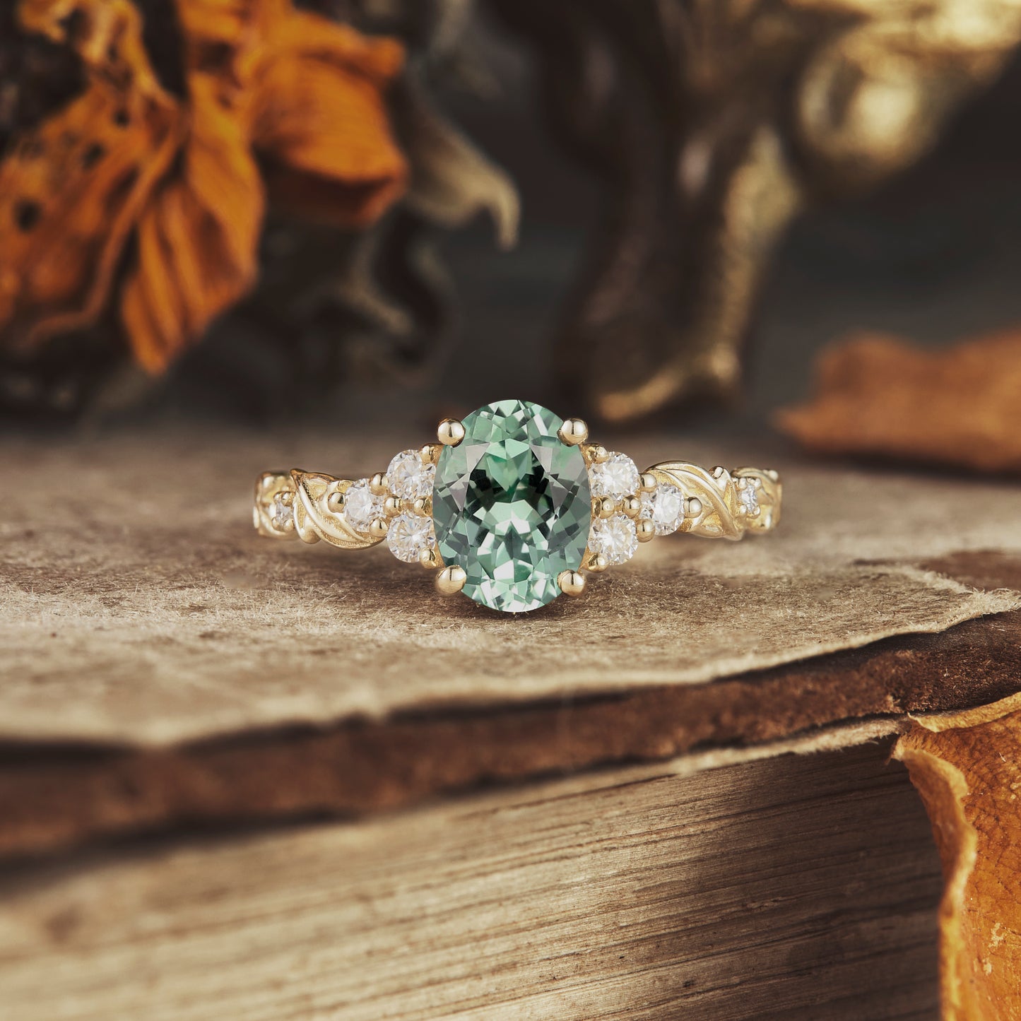 Oval cut green sapphire leaf ring with moissanite, textured gold band.