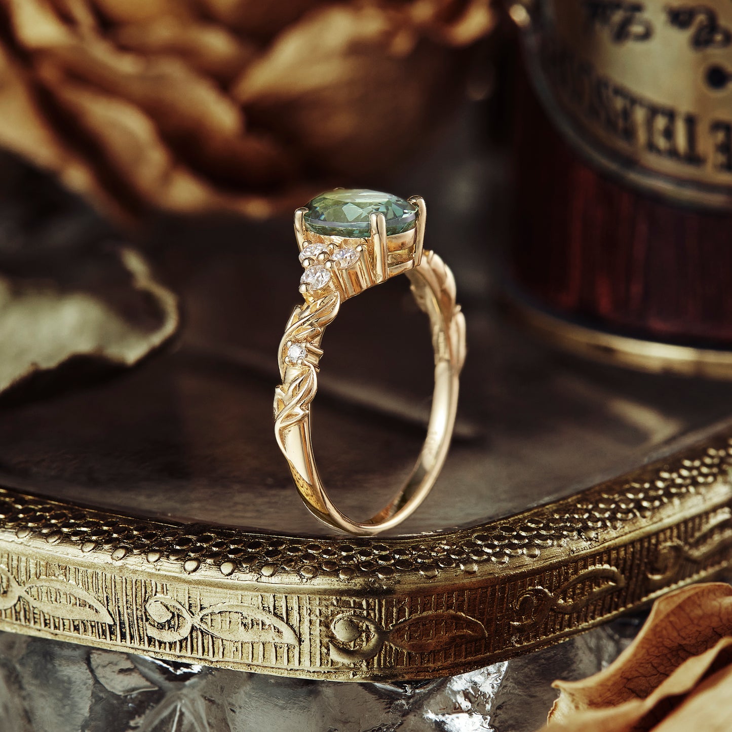 Oval green sapphire engagement ring with textured gold band and moissanite accents.