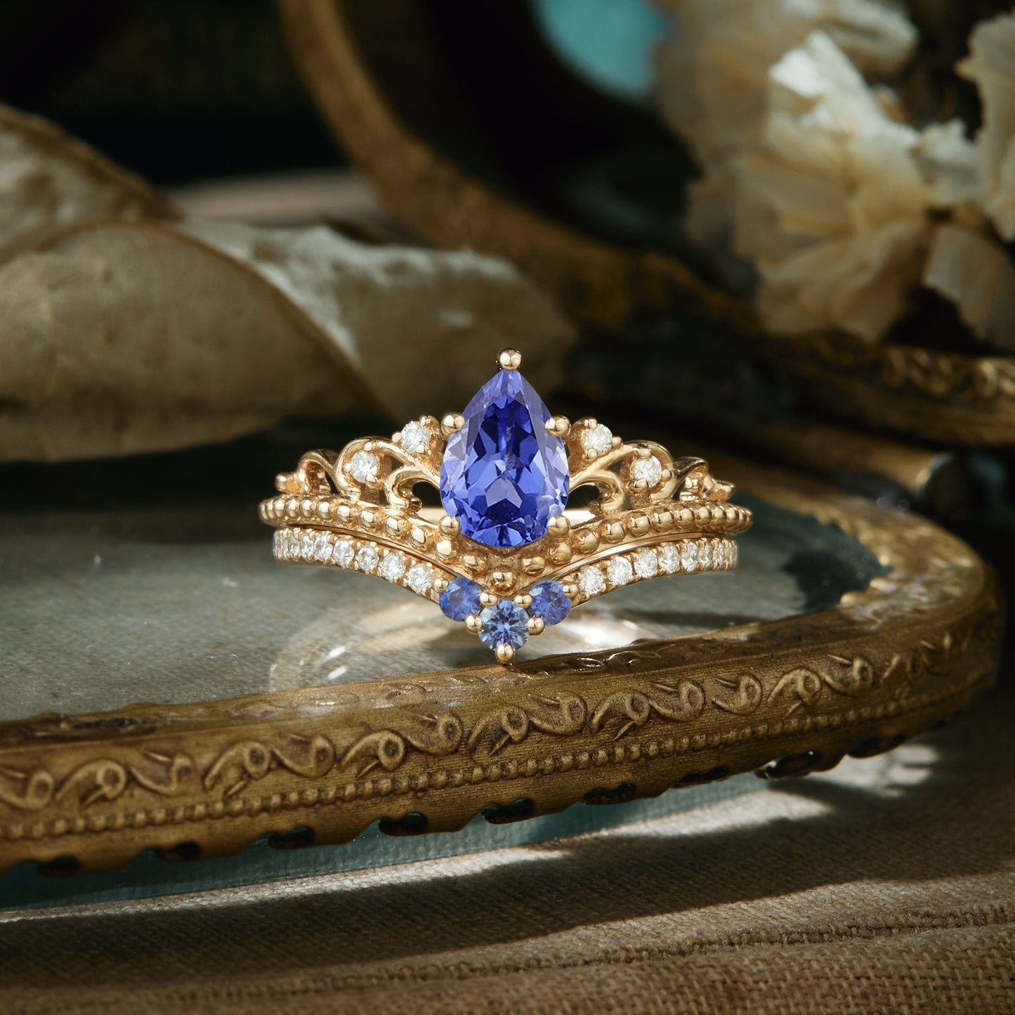 Vintage gold engagement ring with pear-shaped cornflower sapphire and diamond accents.
