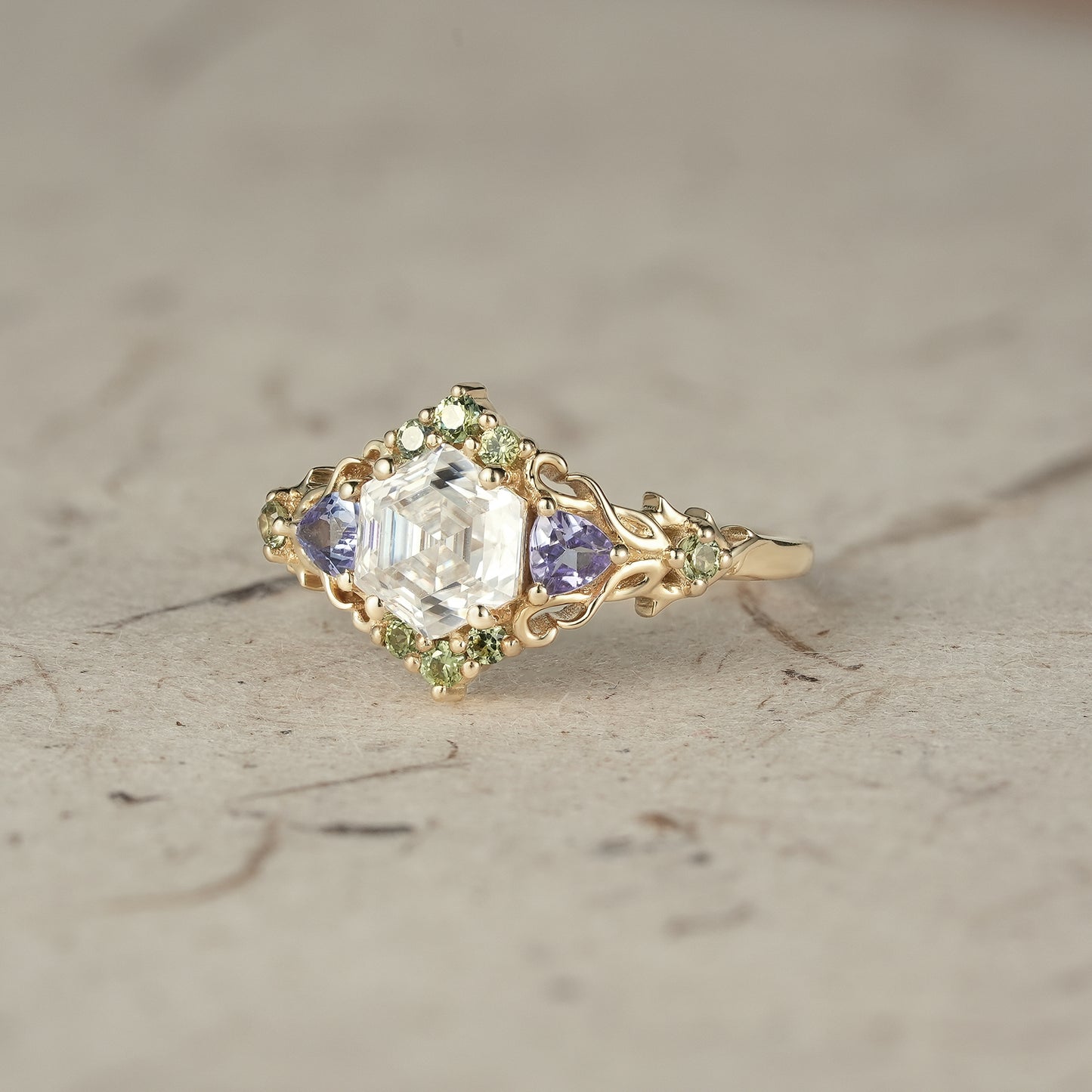 Elegant three-stone moissanite ring with tanzanite and sapphire in gold, nature-inspired design