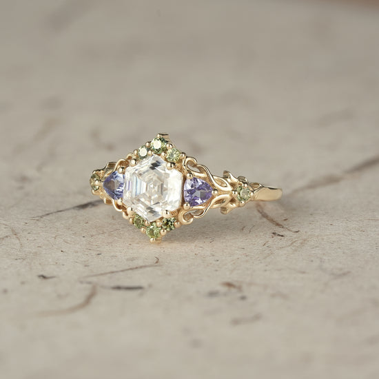 Elegant three-stone moissanite ring with tanzanite and sapphire in gold, nature-inspired design