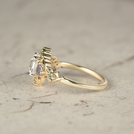 Elegant three-stone moissanite leaf ring with tanzanite and green sapphire accents.