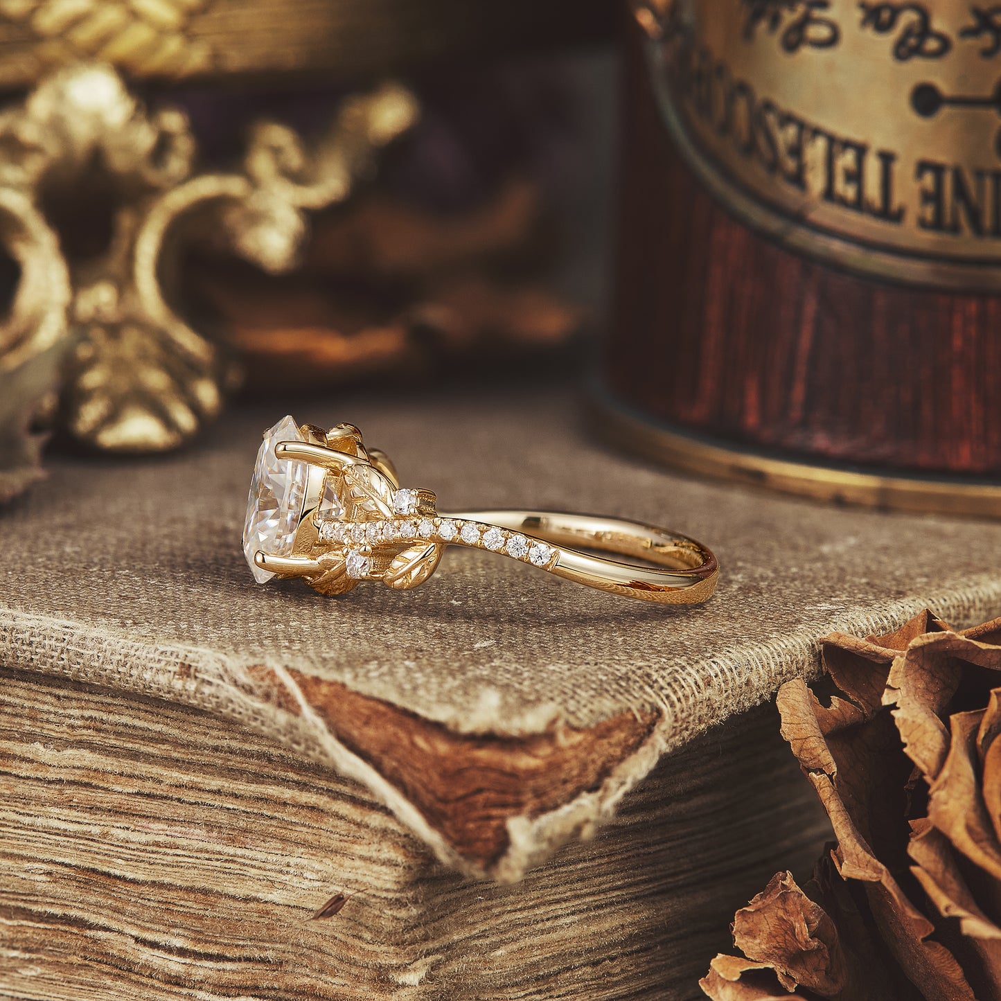 Elegant gold moissanite engagement ring with oval cut and nature-themed details.