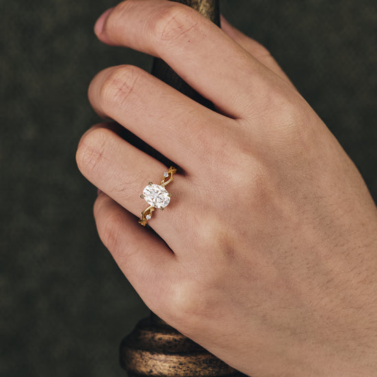 Unique floral moissanite engagement ring with twisted gold band on hand