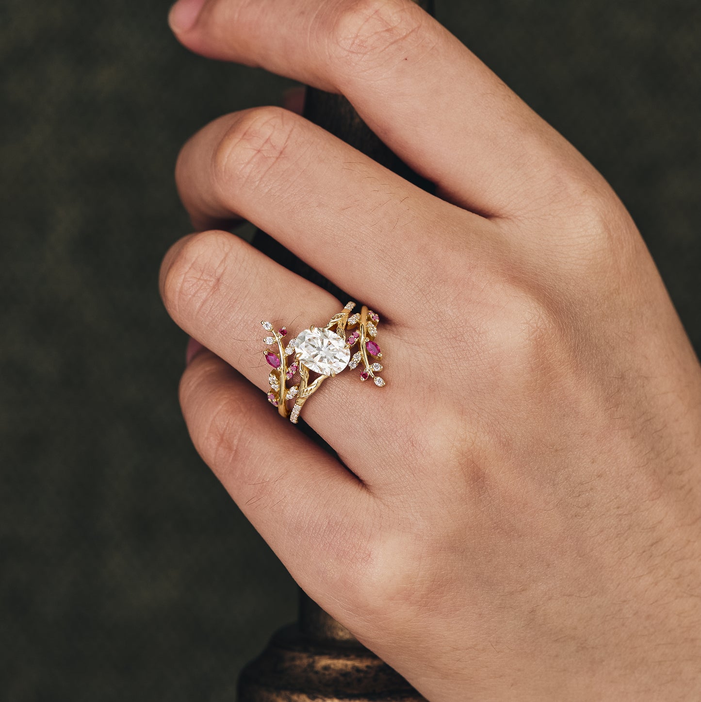 Oval moissanite engagement ring set with ruby accents and floral details in gold