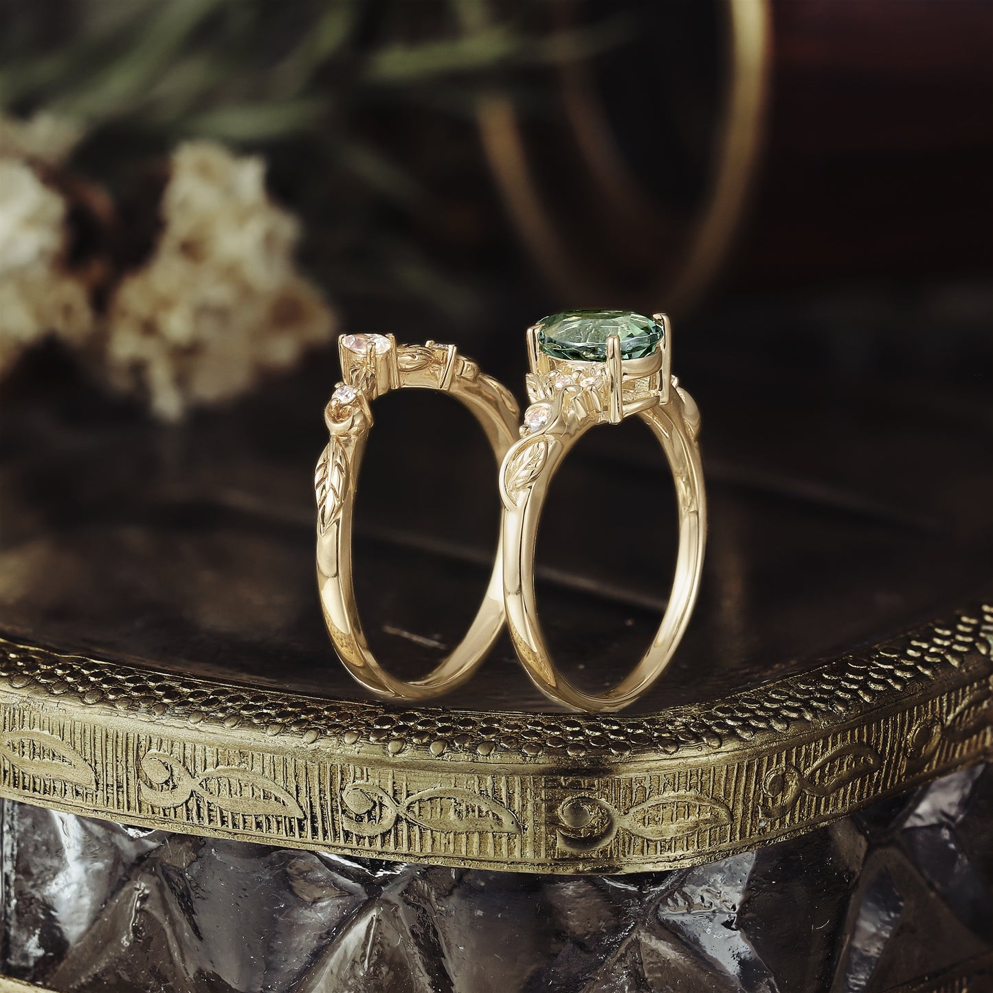 Gold leaf ring set with pear-shaped green sapphire and delicate moissanite accents.