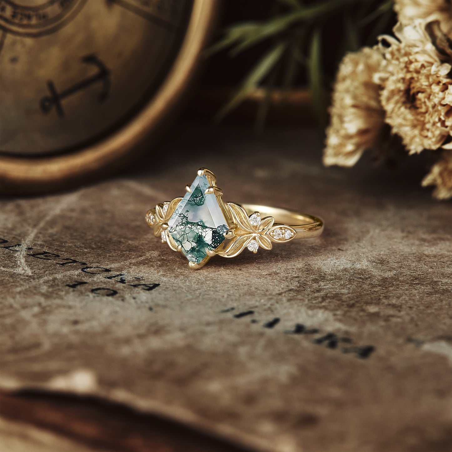 Elegant kite cut moss agate engagement ring with intricate floral details in gold