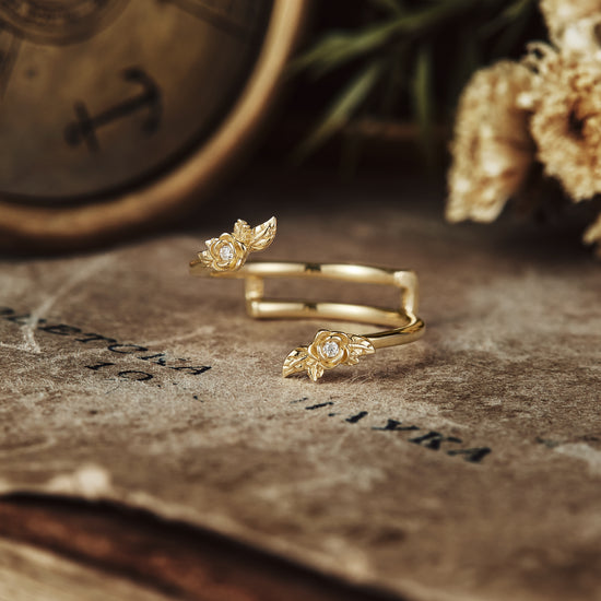Gold wedding ring with floral accents and a diamond, set on rustic background.