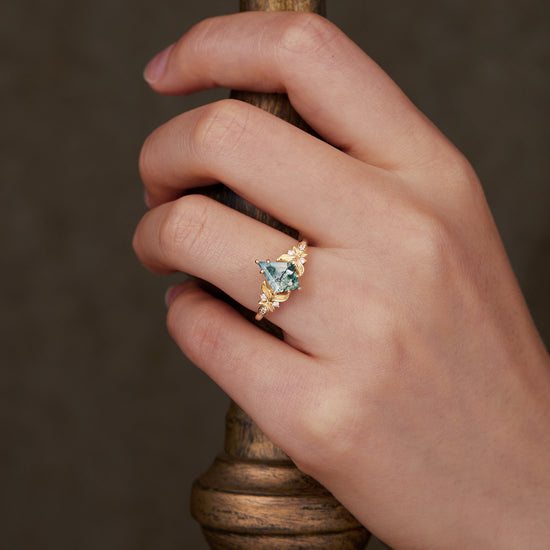 Kite cut moss agate ring with leaf motifs worn on a hand