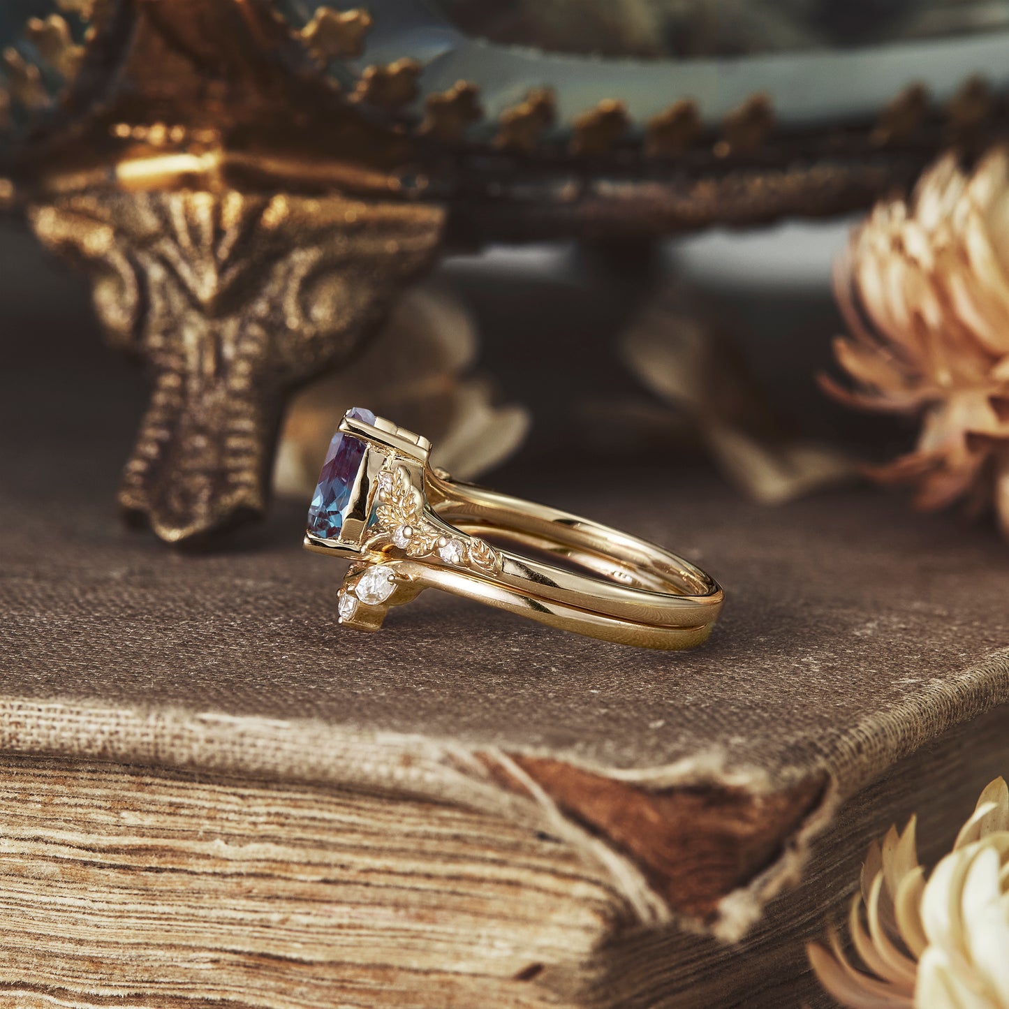Elegant gold ring set with pear-cut alexandrite and diamond leaf details.