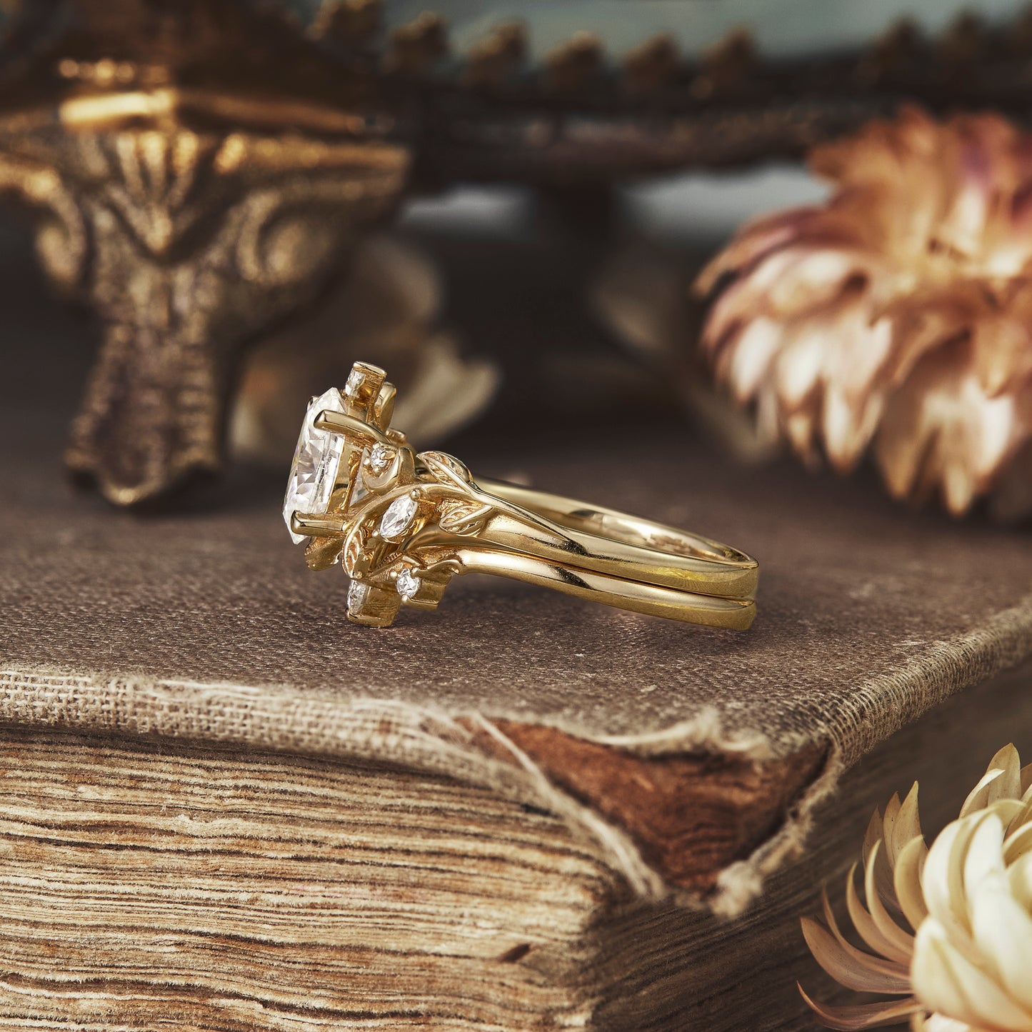 Nature-inspired oval moissanite ring set in yellow gold with floral accents