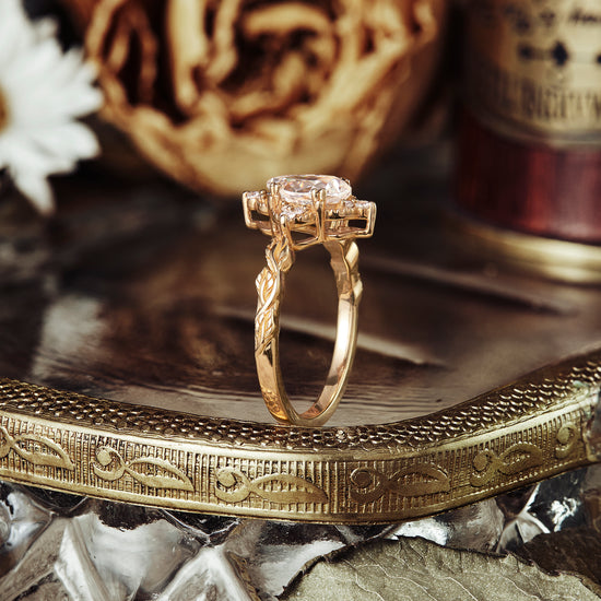 Floral design moissanite engagement ring on reflective surface with dried flowers.