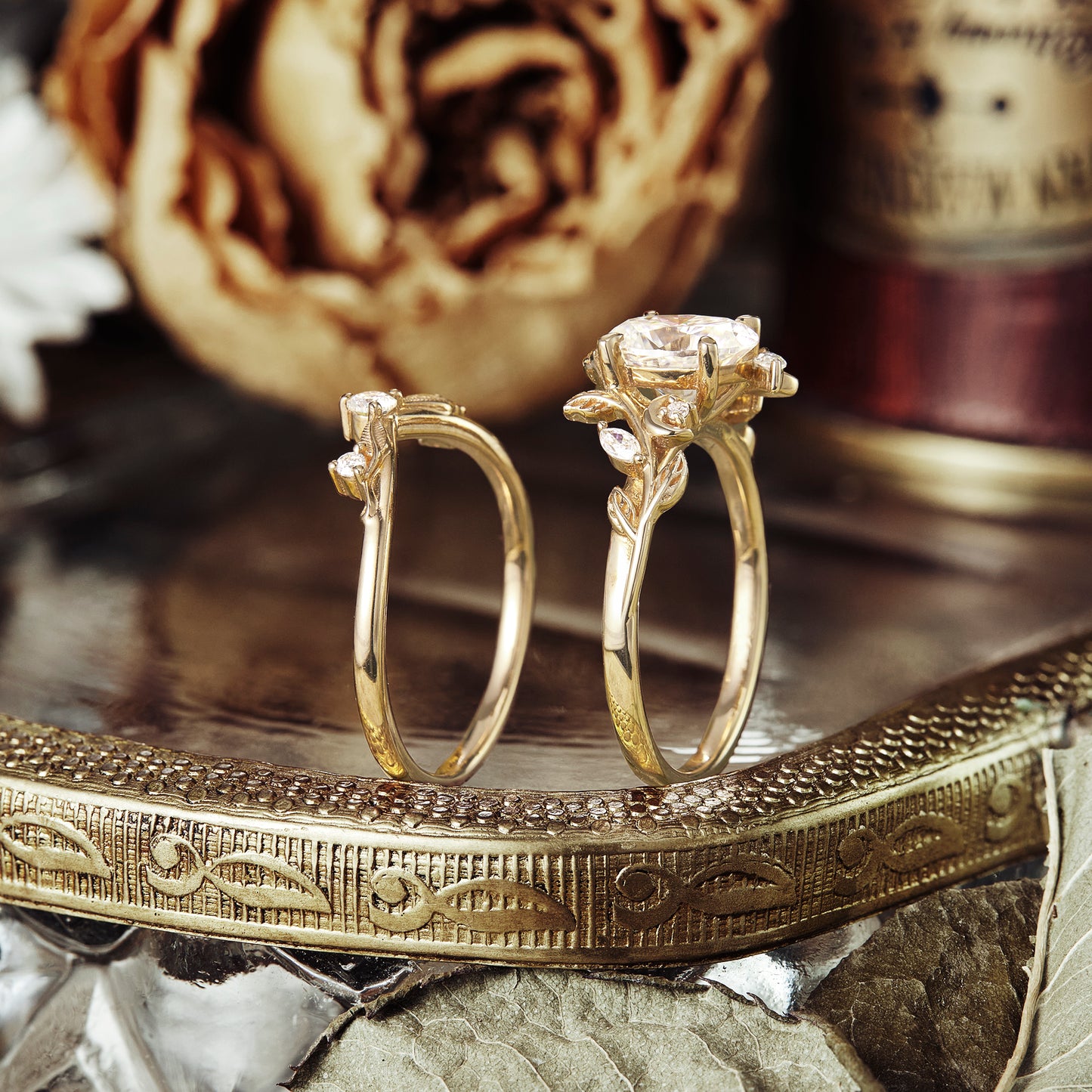 Nature-themed yellow gold engagement ring with floral accents and oval cut moissanite.