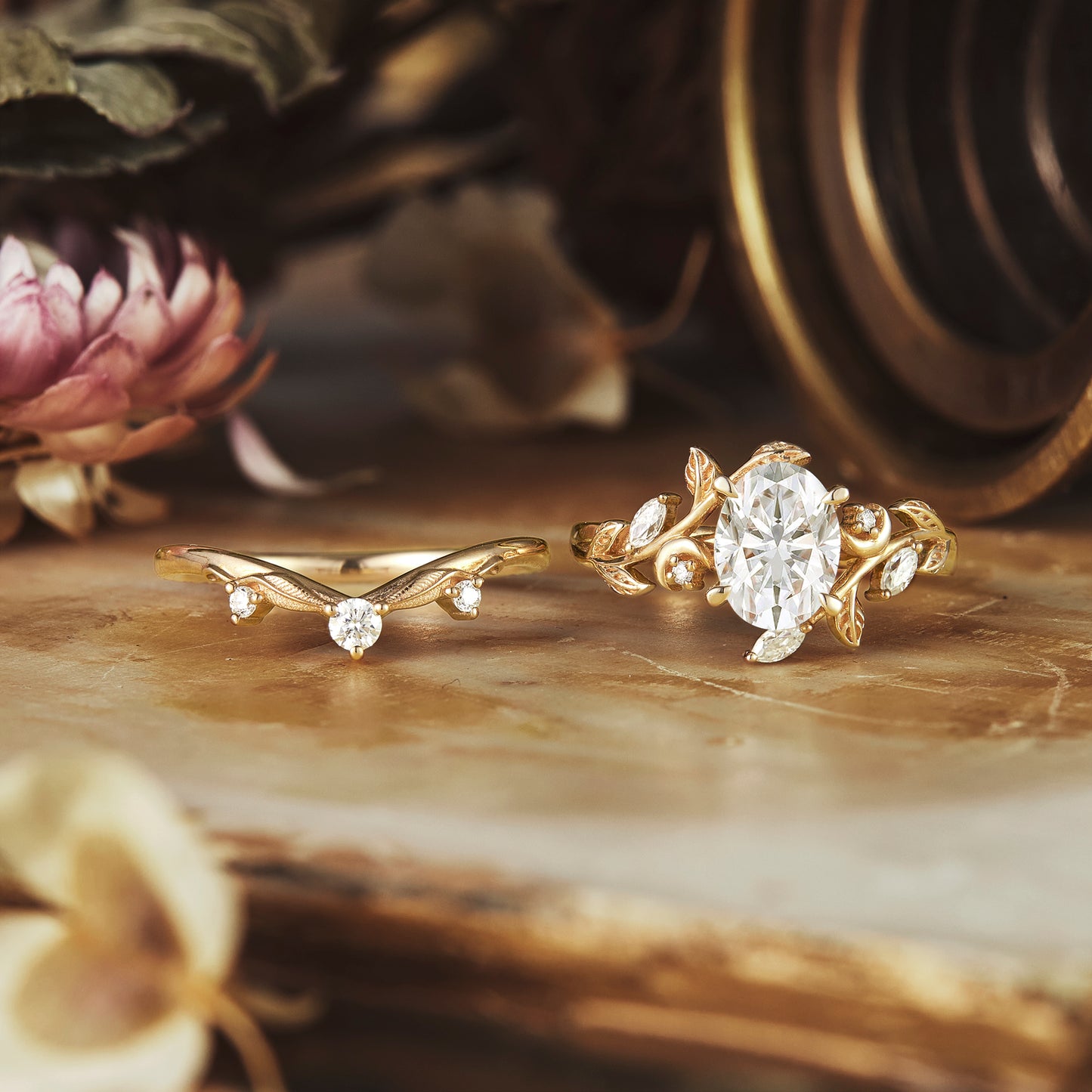 Floral yellow gold engagement and wedding ring set with oval moissanite gemstone.