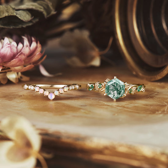 Moss agate and opal rings with emerald accents on vintage surface