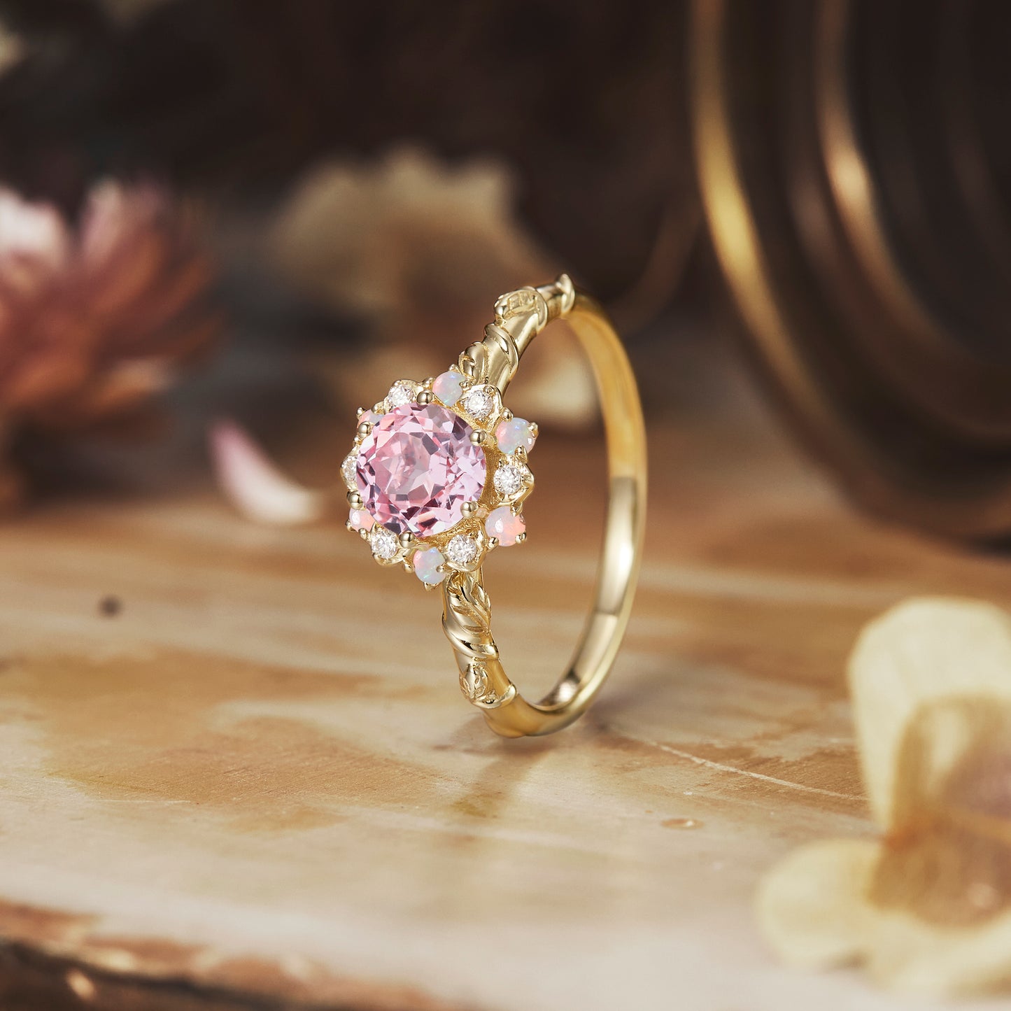 Halo pink Padparadscha ring with twisted band and moissanite accents on elegant surface.