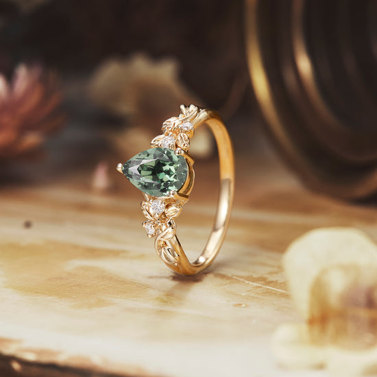 Floral-themed green sapphire pear cut engagement ring in gold with moissanite accents