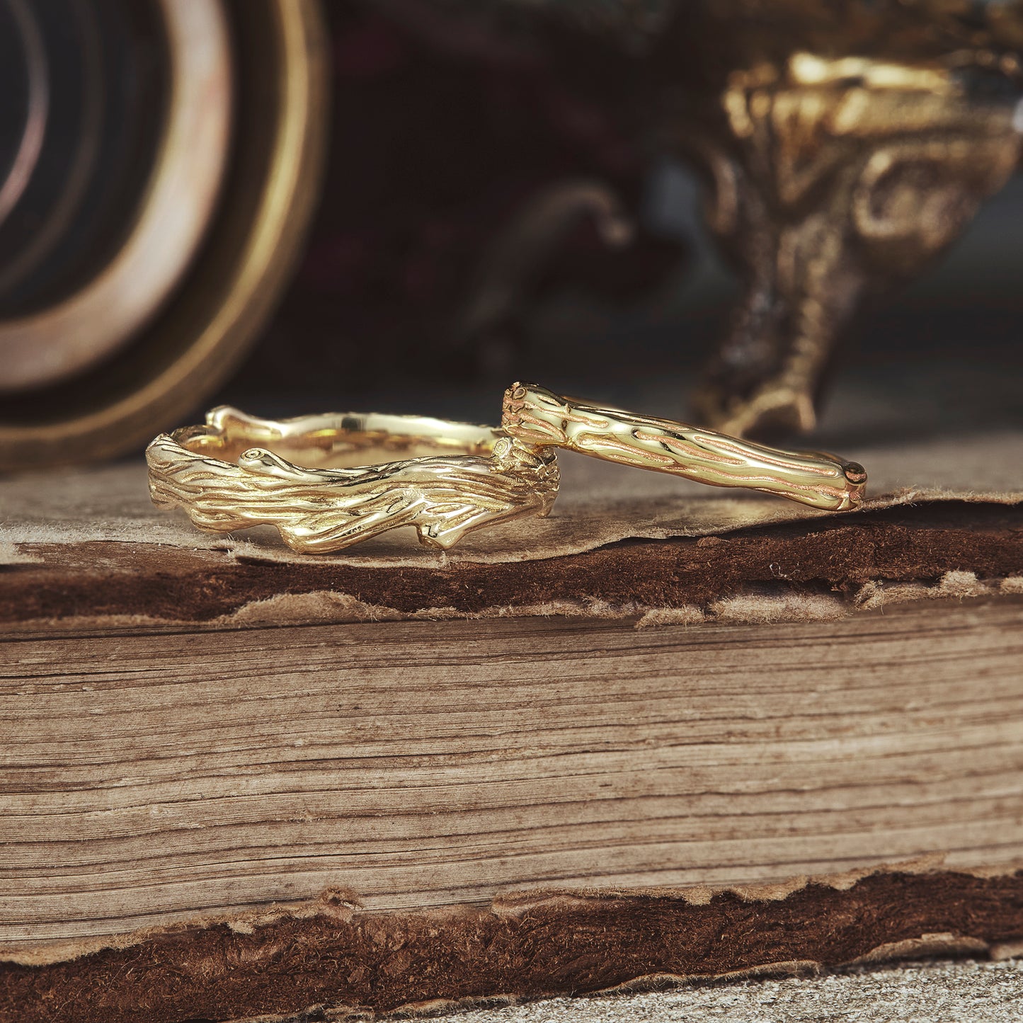Nature-inspired solid gold couple rings with detailed tree pattern design.