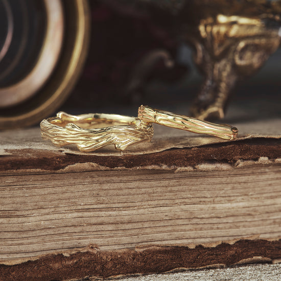 Nature-inspired solid gold couple rings with detailed tree pattern design.