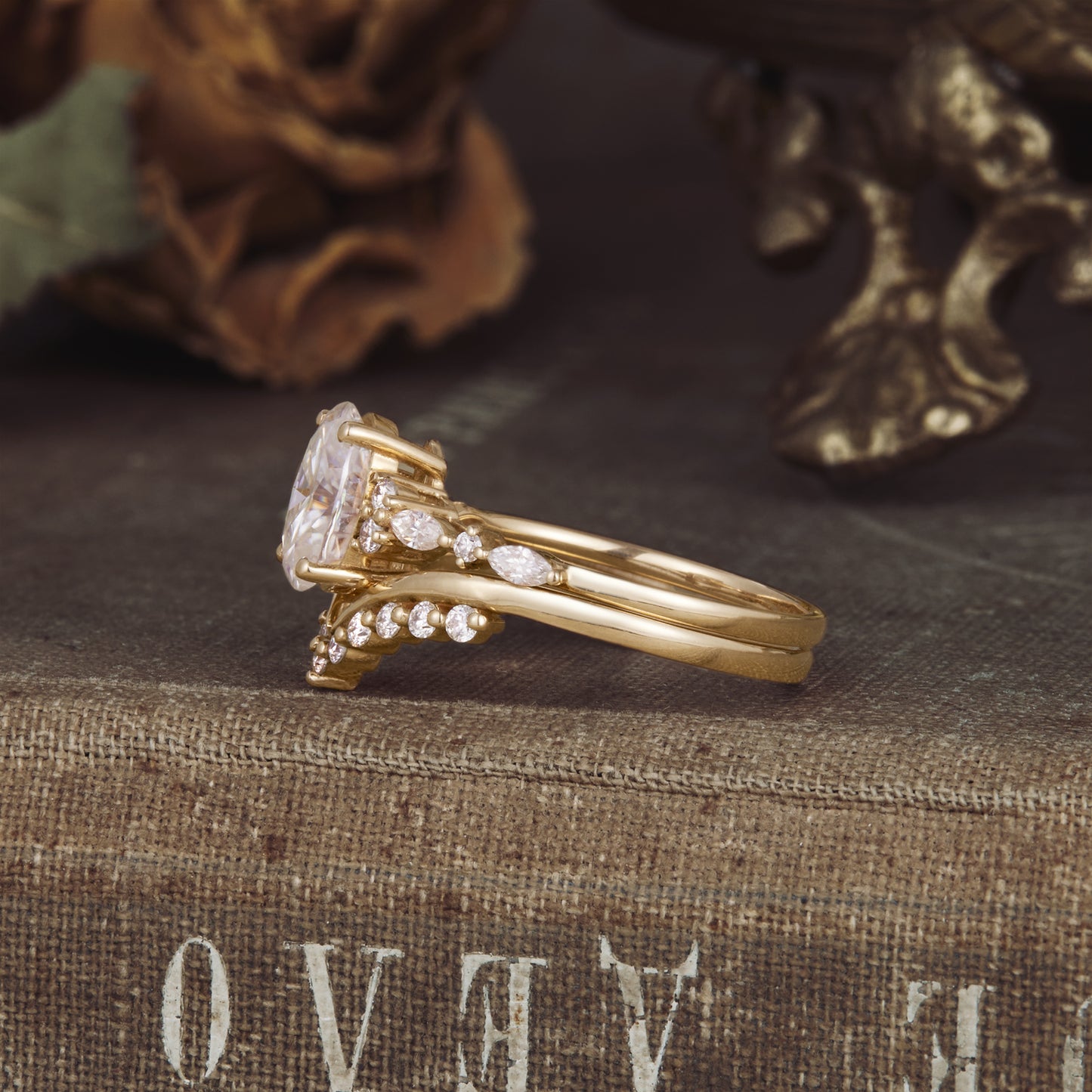 Side view of yellow gold moissanite ring set with oval cut stone and marquise accents.