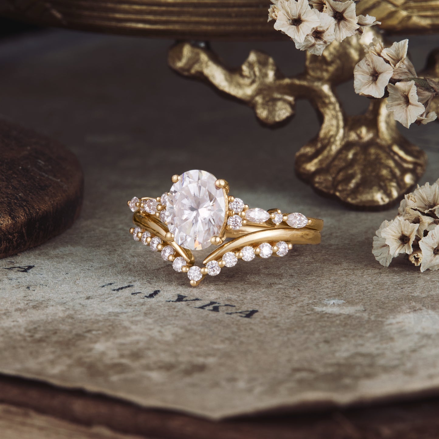 Elegant yellow gold oval moissanite ring set with delicate side stones.