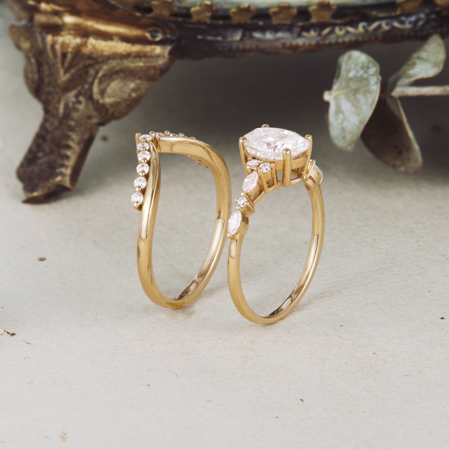 Yellow gold moissanite ring set featuring an oval centerpiece and accent stones.