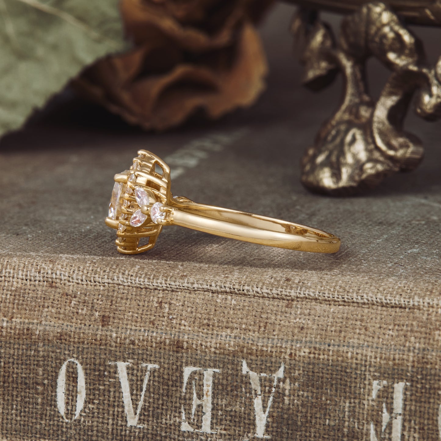 Moissanite halo engagement ring with floral details on vintage background.