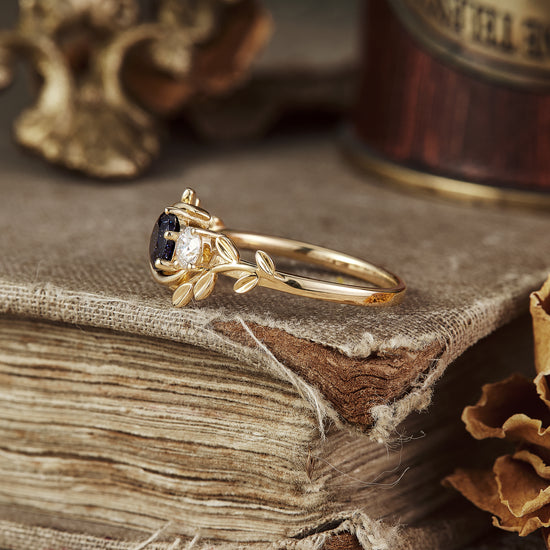 Gold leaf-inspired ring with star sandstone, moissanite, and emerald gemstones.