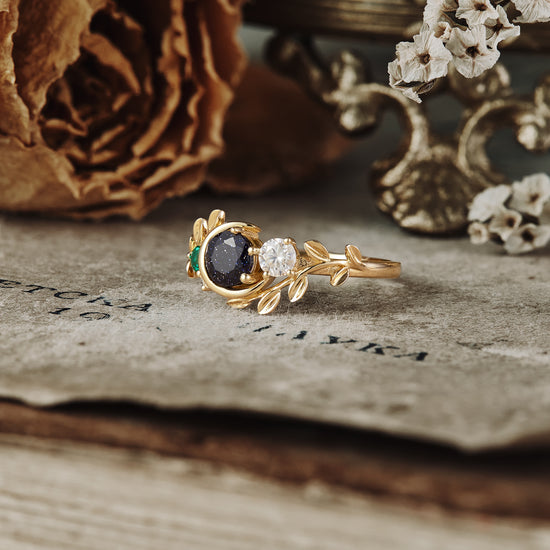 Nature-inspired gold ring with star sandstone, moissanite, and emerald accents.