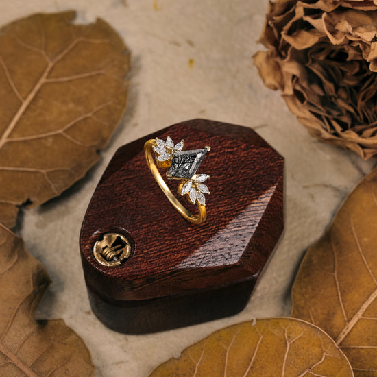 Kite-shaped black rutilated quartz ring with moissanite accents on wooden display