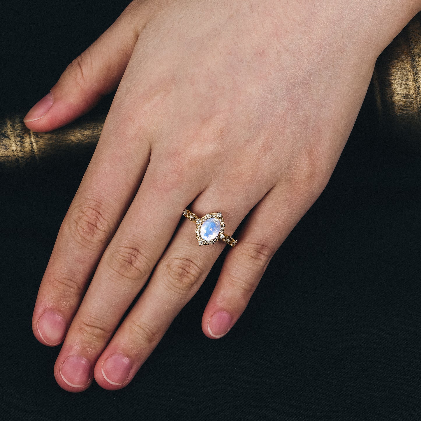 Gold Arabella moonstone halo engagement ring worn on hand