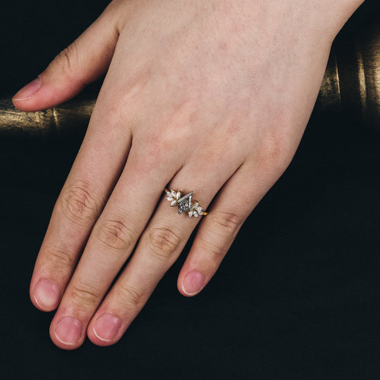 Hand wearing kite-shaped black rutilated quartz ring with marquise moissanite accents