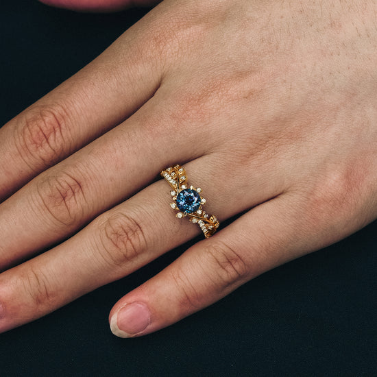 Close-up of gold windmill inspired engagement ring with lab alexandrite and moissanite.