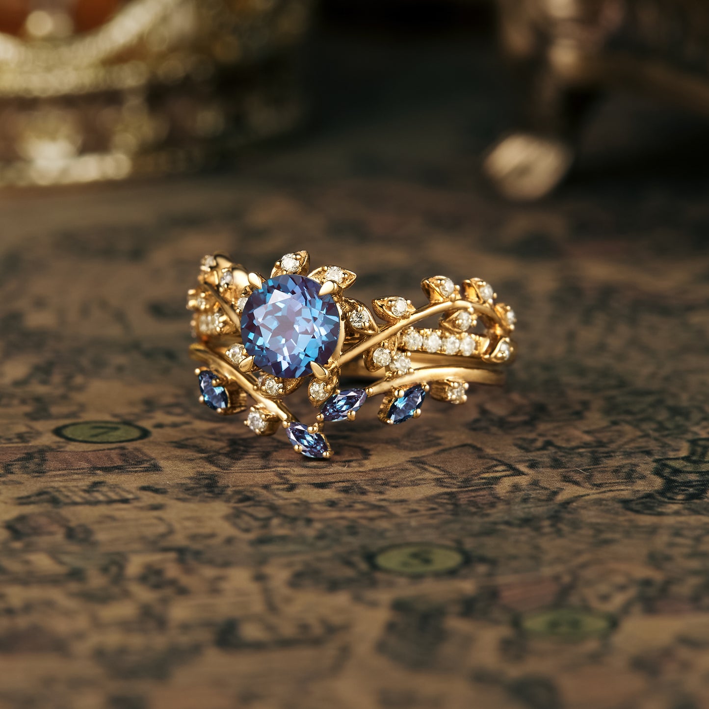 Nature-inspired gold ring featuring large blue gemstone and smaller diamonds.