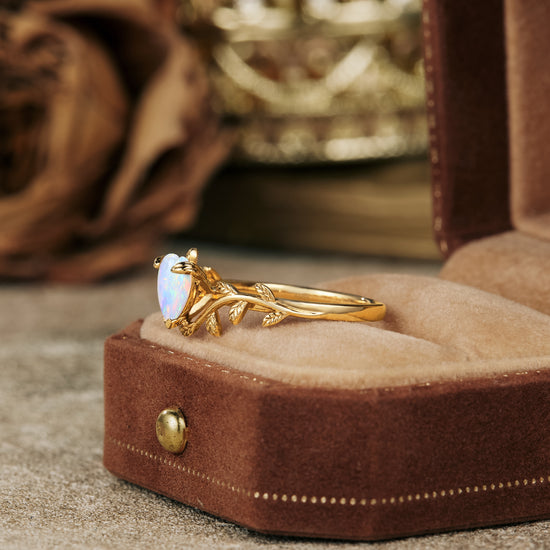 Nature-inspired heart opal ring featuring a gold leaf design in a velvet box.