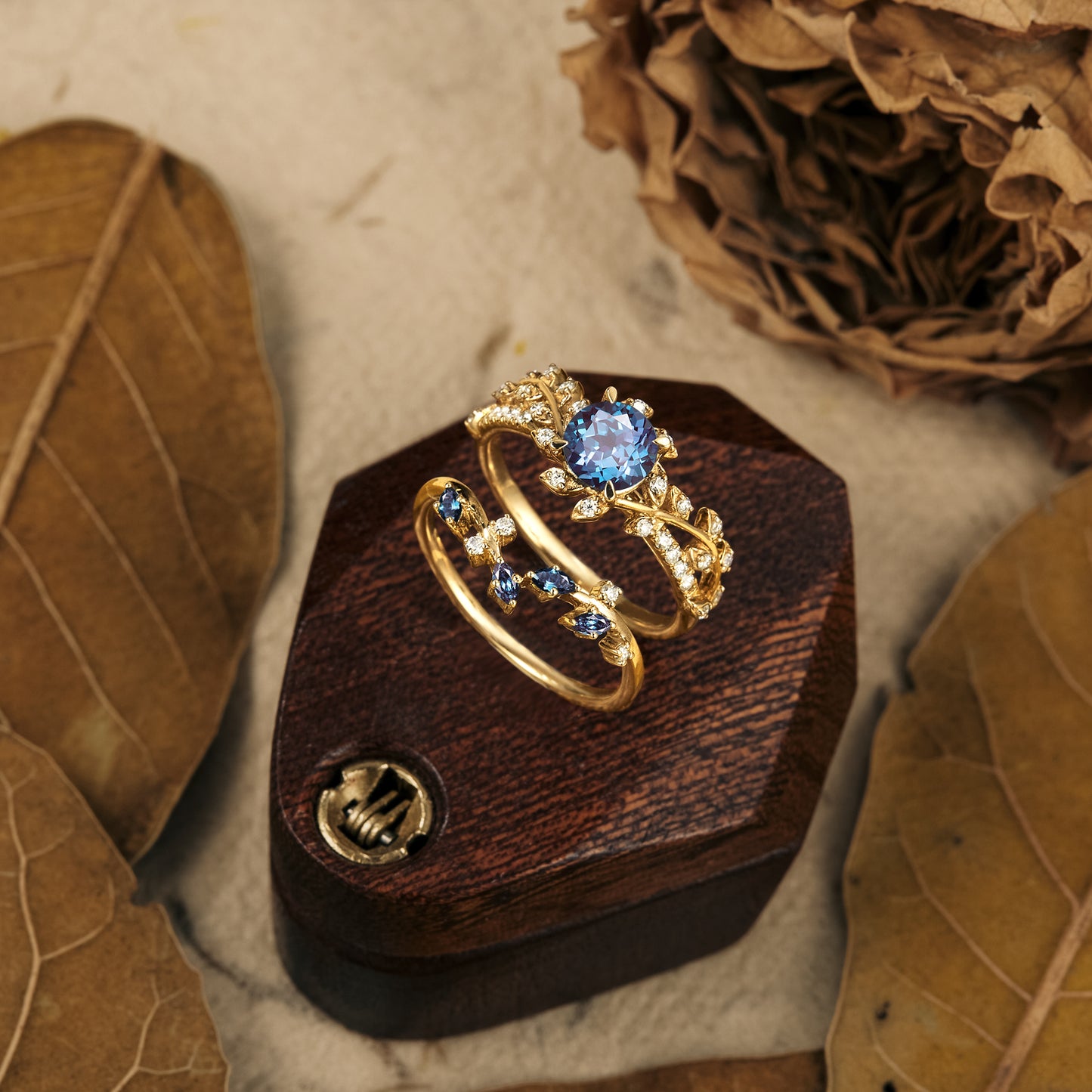Nature-inspired gold ring set featuring large blue gemstone and blue accents.