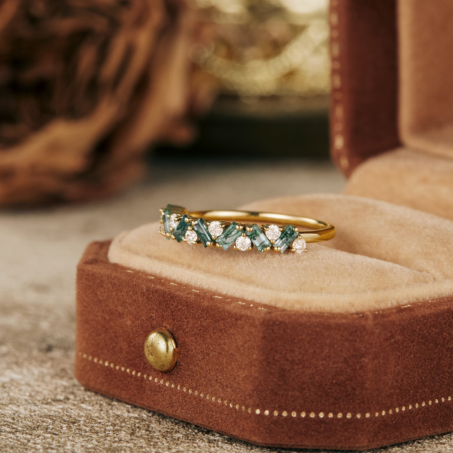 Alt gold wedding band with moissanite and moss agate in velvet box.
