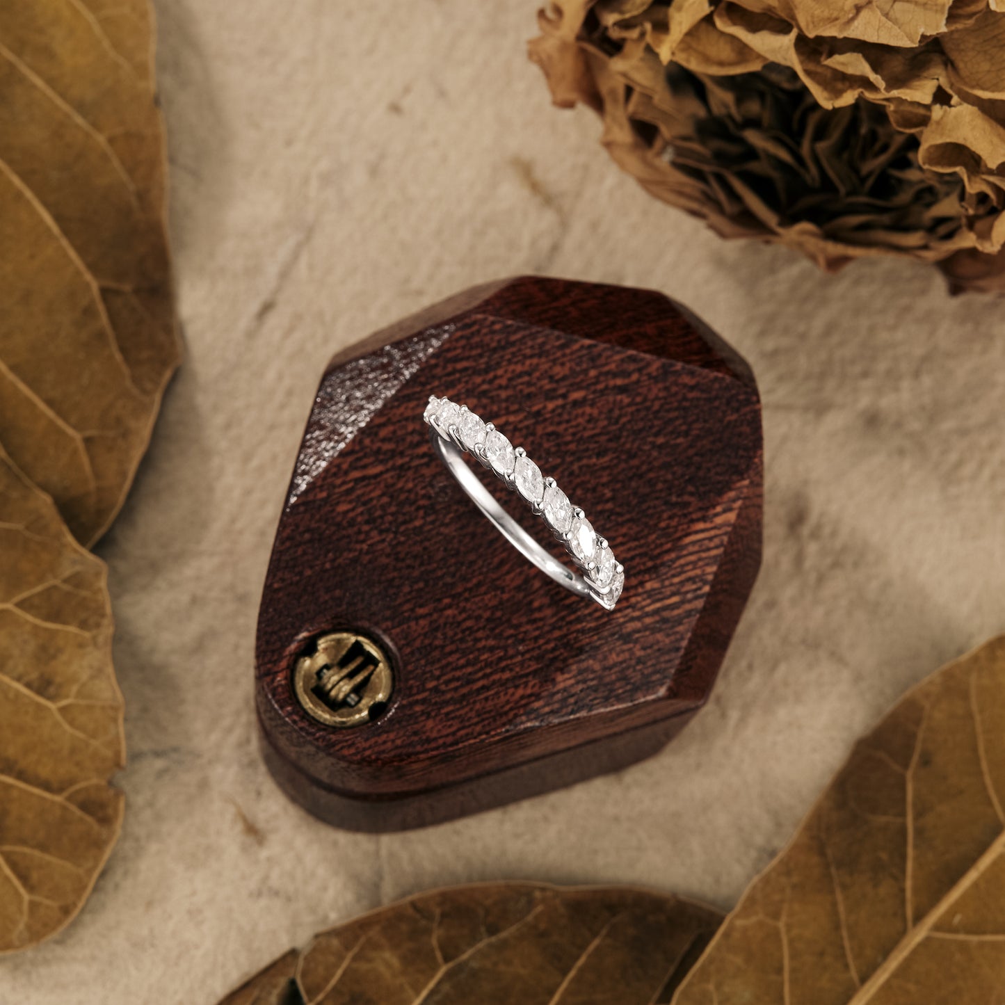 Elegant marquise moissanite wedding band on a rustic wooden box