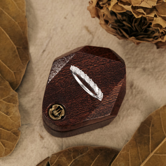 Elegant marquise moissanite wedding band on a rustic wooden box