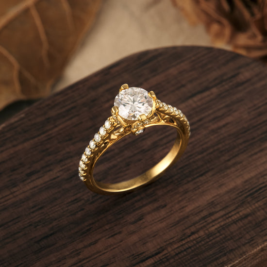 Gold band moissanite engagement ring with round center stone on rustic wood