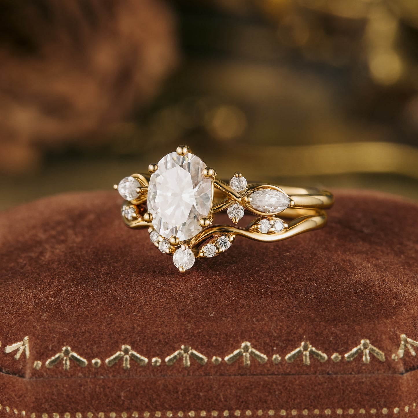 Elegant moissanite ring set featuring an oval center stone and vintage gold band.