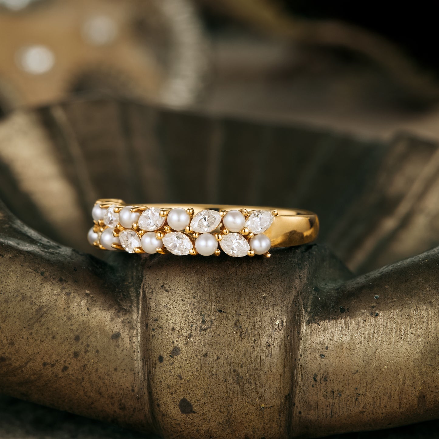Gold wedding band with freshwater pearls and moissanite, displaying elegant craftsmanship.
