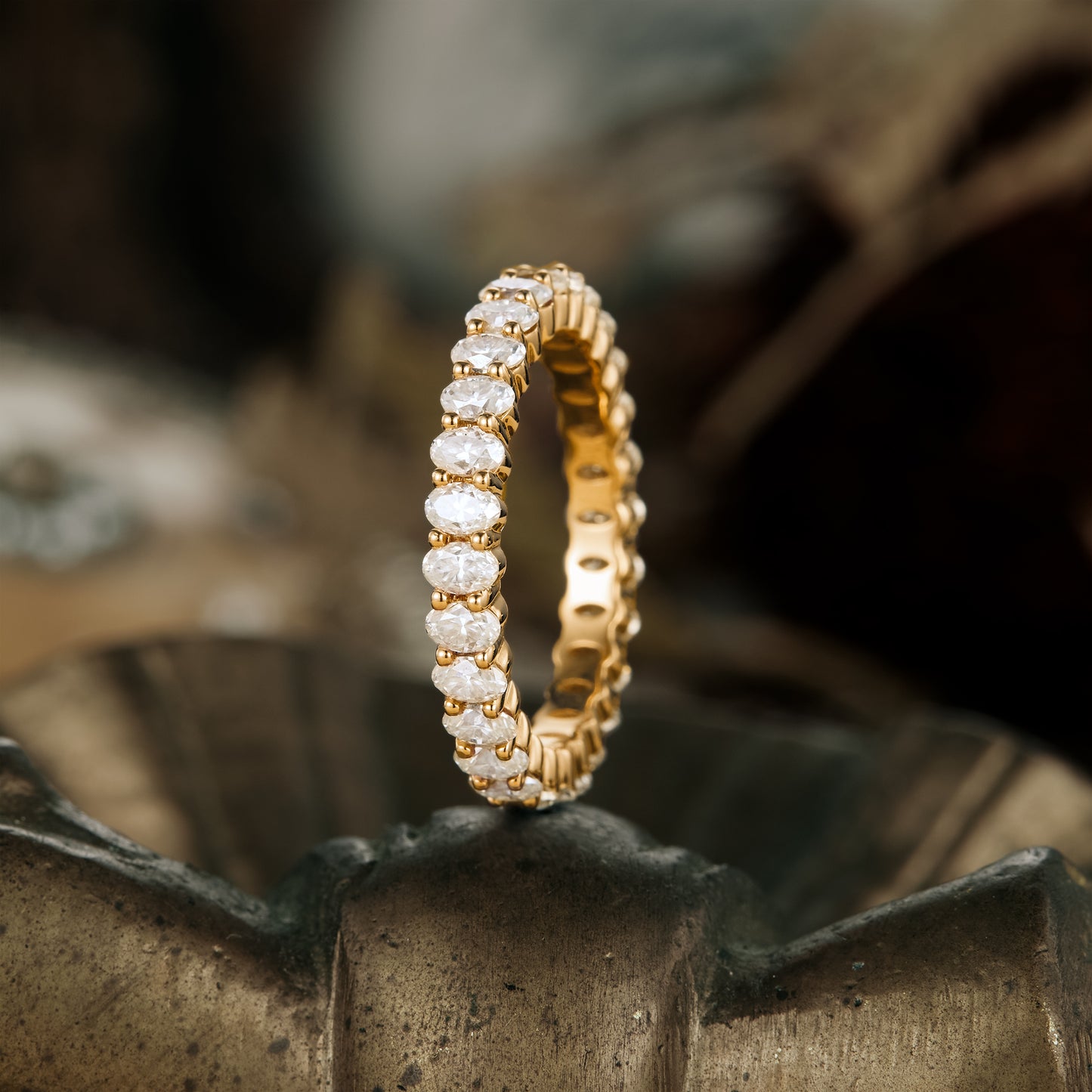 Elegant gold moissanite eternity band showcasing sparkling oval-cut stones.