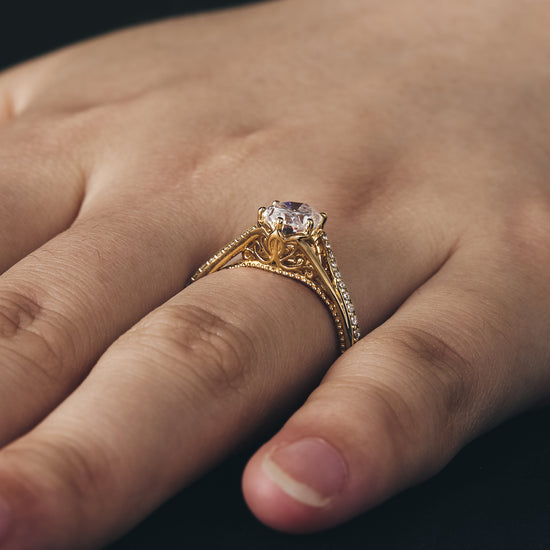 Twisted gold engagement ring set featuring oval moissanite on a woman's hand.