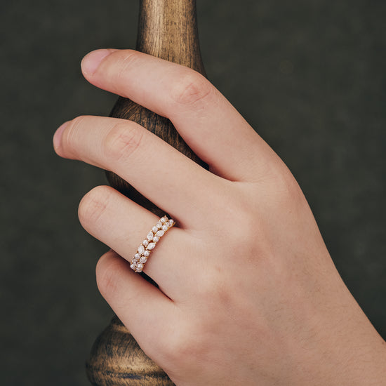 Gold wedding band with freshwater pearls and moissanite worn on hand