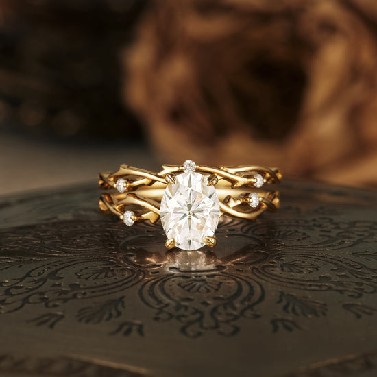 Floral engagement ring set with oval moissanite and twisted gold band.