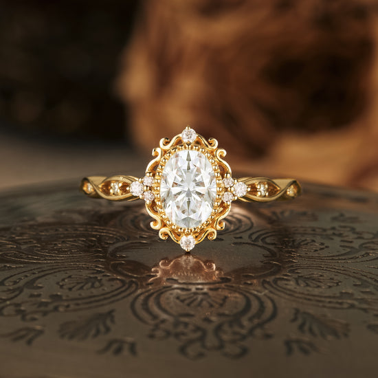 Ornate oval moissanite engagement ring in gold with accent stones