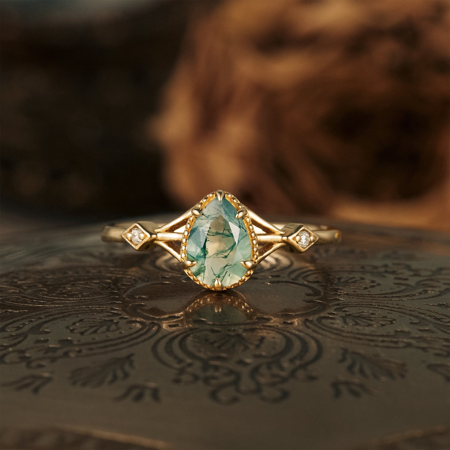 Moss agate pear-shaped engagement ring with gold band and moissanite accents