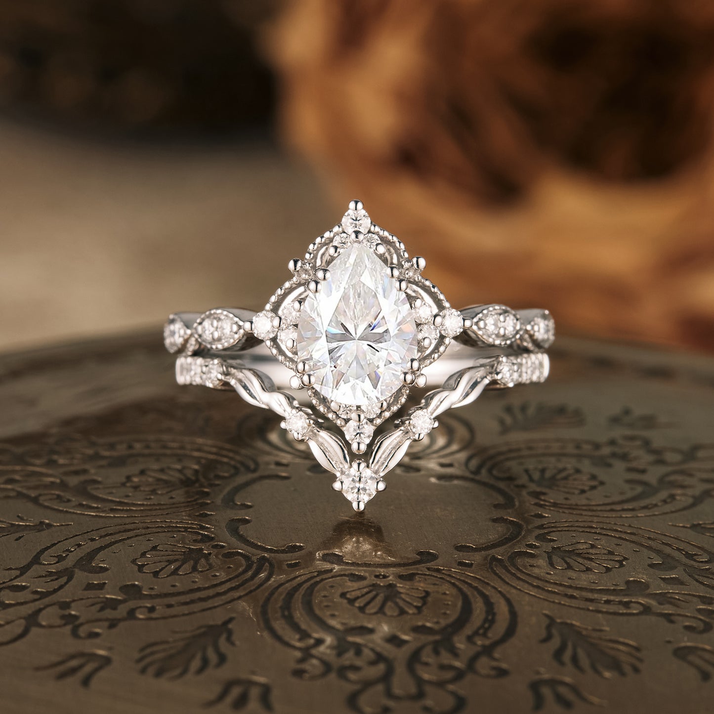 Pear-shaped moissanite engagement ring set with accent stones in silver.