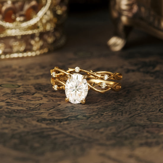 Nature-inspired engagement ring set with oval moissanite and intricate gold band.